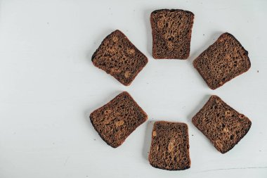 Beyaz ahşap arka planda kuru üzümlü taze kahverengi ekmek dilimleri. Üst Manzara. Kopyala, metin için boşluk.