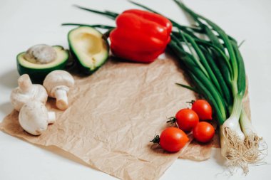 Beyaz ahşap bir arka planda farklı taze sebzeler. Kopyala, metin için boşluk.