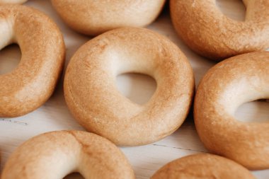 Beyaz ahşap arka planda küçük yuvarlak simitler. Kopyala, metin için boşluk.