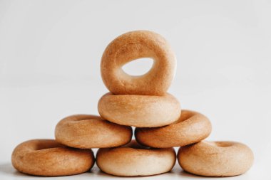 Beyaz ahşap bir zeminde piramit şeklinde mini yuvarlak simit kurutmak ya da kurutmak. Kopyala, metin için boşluk.