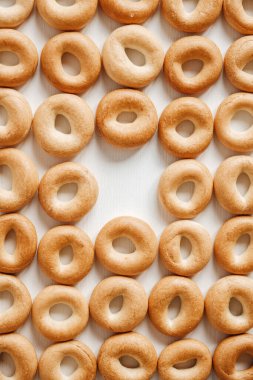 Beyaz ahşap arka planda küçük yuvarlak simitler. Üst Manzara. Kopyala, metin için boşluk.