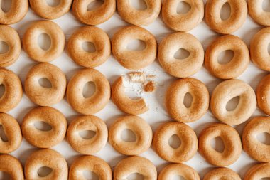 Beyaz ahşap arka planda küçük yuvarlak simitler. Üst Manzara. Kopyala, metin için boşluk.