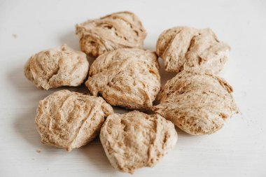 Çiğ susuz soya eti ya da beyaz ahşap arka planda soya parçaları. Kopyala, metin için boşluk.