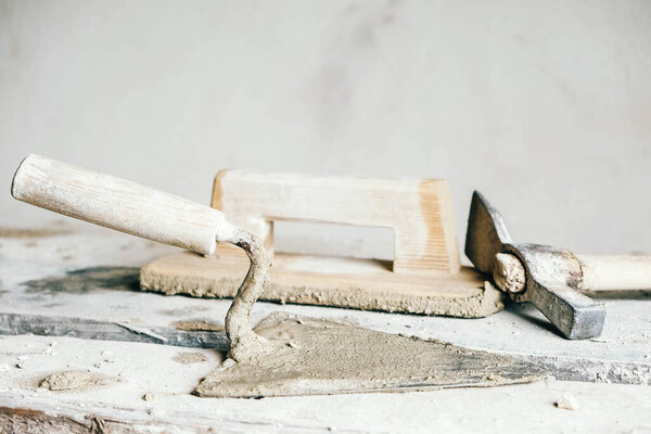 Старые строительные инструменты для штукатурки на старинной деревянной скамейке. Троянские и другие каменные орудия. Копирование, пустое место для текста.