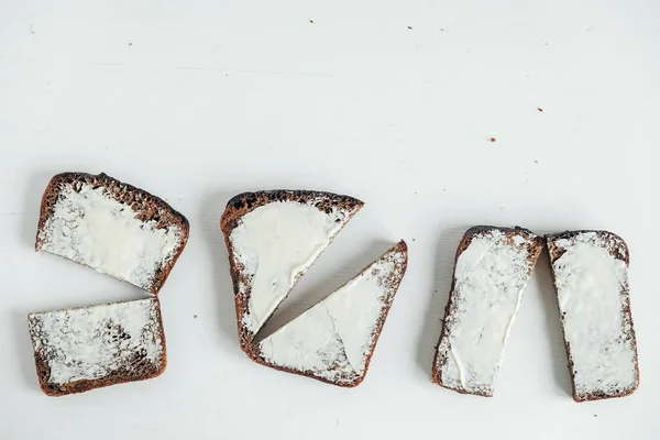 Plasterek Brązowego Chleba Masłem Białym Drewnianym Tle Widok Góry Kopiowanie — Zdjęcie stockowe