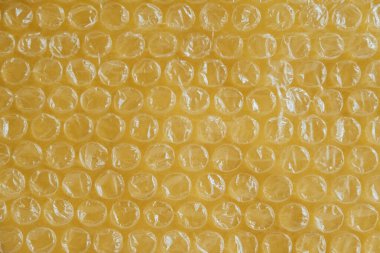 Sarı arka planda hava kabarcıkları olan ambalajlar. Kabarcık ambalajı, ambalaj, hava kabarcığı filmi. Üst Manzara. Kopyala, metin için boşluk.