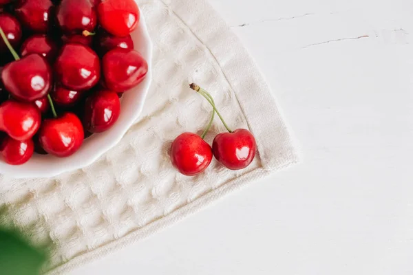 Φρέσκα Ζουμερά Κόκκινα Κεράσια Λευκό Πιάτο Στο Λευκό Ξύλινο Φόντο — Φωτογραφία Αρχείου