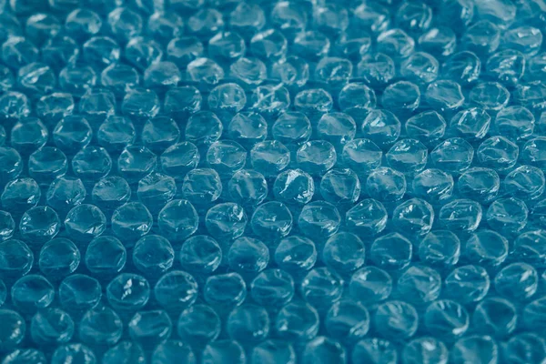 Packaging with air bubbles on a blue background. Bubble wrap texture, packaging, air bubble film. Copy, empty space for text.