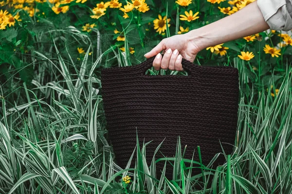 Mano Mujer Sosteniendo Una Bolsa Punto Marrón Sobre Fondo Hierba — Foto de Stock