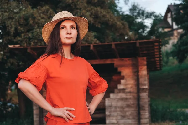 Schöne Frau Mit Strohhut Roter Kleidung Steht Auf Dem Hintergrund — Stockfoto