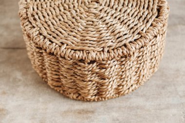 Eski ahşap bir masada yuvarlak bir hasır sepet. Kopyala, metin için boşluk.