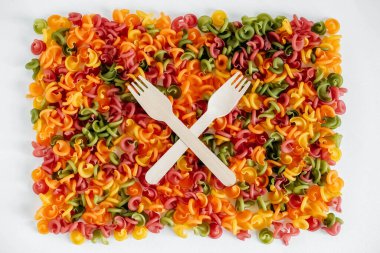 Arkaplan resmi olarak ahşap çatallı çok renkli makarna. Üst Manzara. Kopyala, metin için boşluk.