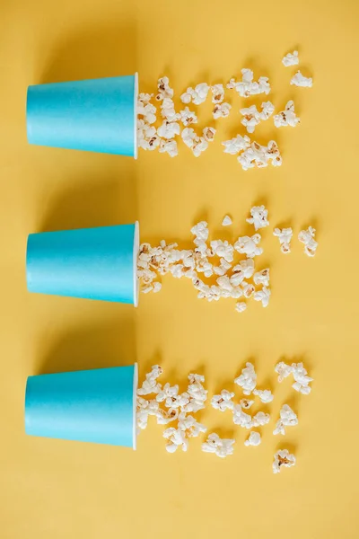 Popcorn Blå Papperskoppar Utspridda Gul Bakgrund Högst Upp Kopiera Tomt — Stockfoto