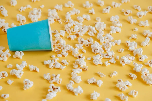 Popcorn Modrém Papírovém Kelímku Roztroušený Žlutém Pozadí Minimalistický Koncept Kopírovat — Stock fotografie