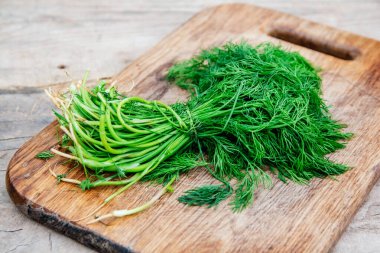 Ahşap masa arkasında maydanoz demeti. Ahşap arka planda taze maydanoz.