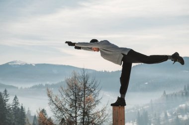Yoga yapan ve kış dağlarında egzersiz yapan ve hayatın tadını çıkaran bir adam. Kopyala, metin için boşluk.