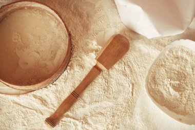 Masaya saçılmış beyaz buğday unu, ahşap merdane, kırsal elek ve aşçı şapkası. Mutfakta lezzetli kurabiyeler pişir. Üst Manzara. Kopyala, metin için boşluk.