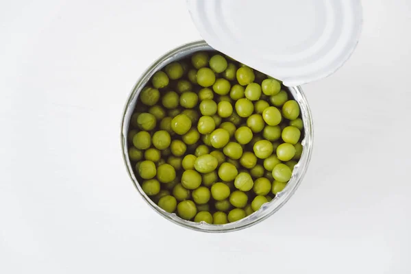 打开的铝金属罐头中的绿色甜豌豆罐头放在白桌上 顶部视图 空的文字空间 — 图库照片