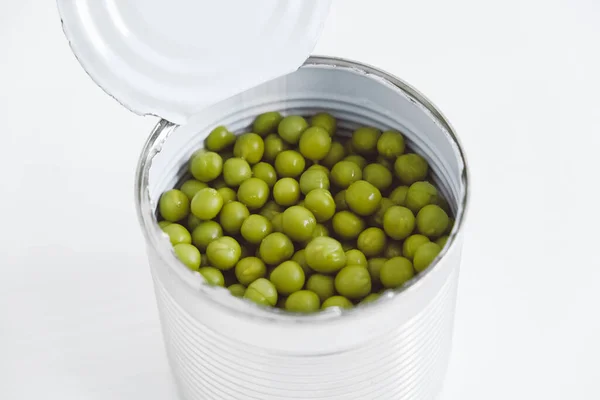 打开的铝金属罐头中的绿色甜豌豆罐头放在白桌上 顶部视图 空的文字空间 图库照片