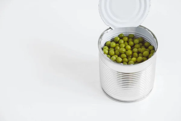 オープンアルミ金属で缶詰の緑の甘いエンドウ豆は白いテーブルの上にすることができます テキストのコピー 空のスペース ストック画像