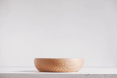 Beyaz masa arkasında boş ahşap bir tabak. Kopyala, metin için boşluk.