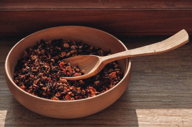 Tahta kaşıkta kuru meyve çayı ve ahşap arka planda ahşap bir tabak. Kopyala, metin için boşluk.