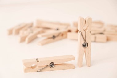 Beyaz masa arkasında bir sürü tahta mandal var. Ev işi konsepti. Kopyala, metin için boşluk.