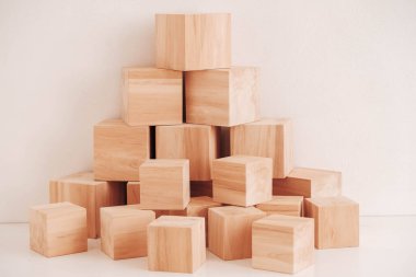 Tahta bloklar piramidi beyaz arka planda doğal ahşaptan. Kopyala, metin için boşluk.