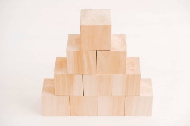 Tahta bloklar piramidi beyaz arka planda doğal ahşaptan. Kopyala, metin için boşluk.