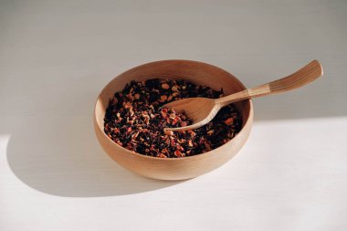 Tahta kaşıkta kuru meyve çayı ve beyaz arka planda ahşap bir tabak. Üst Manzara. Kopyala, metin için boşluk.