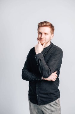 Beyaz arka planda siyah gömlekli genç bir adamın portresi. Kopyala, metin için boşluk.