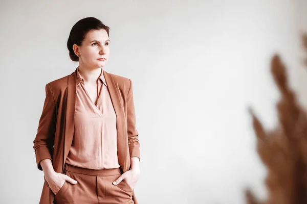 Frau im braunen Business-Anzug auf weißem Hintergrund. Kopie, leerer Raum — Stockfoto