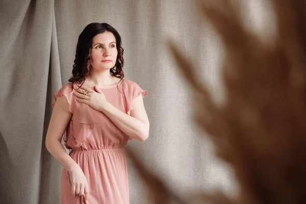 Schöne Brünette Frau Einem Rosa Kleid Auf Einem Leinenhintergrund Kopieren — Stockfoto