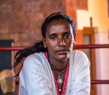 Lalibela, Etiyopya - 14 Şubat 2020: Geleneksel giysili genç kadın bir kahve seremonisi hazırlıyor. Bu tören Etiyopya kültürünün önemli bir parçasıdır..
