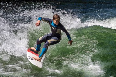 Münih, Almanya - 13 Temmuz 2019: Münih şehir nehrinde sörfçü, Eisbach adı verilen kentsel çevrede sörf yapan insanlarla ünlüdür.