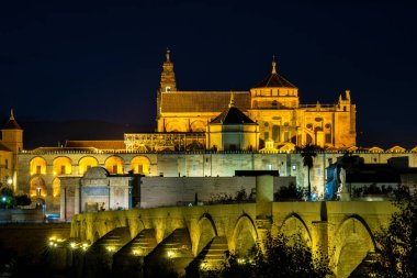 Cordoba, İspanya - 31 Ekim 2019: Mezquita-Katedral ve Puente Romano - Cami-Katedral ve gece İspanya 'nın Endülüs kentindeki Roma Köprüsü