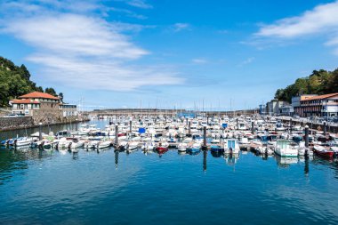 Mutriku limanında beyaz yelkenli tekneler ve İspanya 'nın Bask bölgesinde eski bir kasaba. Cantabric Denizi 'ne bakan Motrico marinasına yanaşan renkli teknelerin görüntüsü.