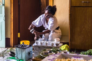 Axum, Etiyopya - 9 Şubat 2020: Geleneksel giysiler içinde genç bir kadın bir kahve seremonisi hazırlıyor. Bu tören Etiyopya kültürünün önemli bir parçasıdır..