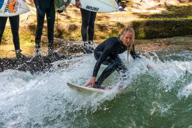 Münih, Almanya - 13 Temmuz 2019: Münih şehir nehrinde sörfçü, Eisbach adı verilen kentsel çevrede sörf yapan insanlarla ünlüdür.