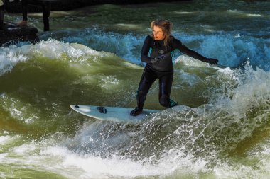 Münih, Almanya - 13 Temmuz 2019: Münih şehir nehrinde sörfçü, Eisbach adı verilen kentsel çevrede sörf yapan insanlarla ünlüdür.