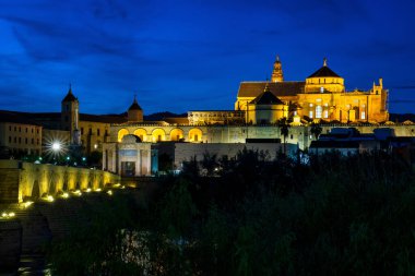 Cordoba, İspanya - 31 Ekim 2019: Mezquita-Katedral ve Puente Romano - Cami-Katedral ve gece İspanya 'nın Endülüs kentindeki Roma Köprüsü
