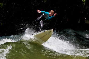Münih, Almanya - 13 Temmuz 2021: Münih şehir nehrinde sörfçü, Eisbach adı verilen kentsel çevrede sörf yapan insanlarla ünlüdür.