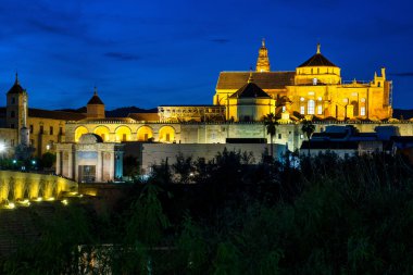 Cordoba, İspanya - 31 Ekim 2019: Mezquita-Katedral ve Puente Romano - Cami-Katedral ve gece İspanya 'nın Endülüs kentindeki Roma Köprüsü