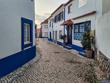 Traditional white houses with blue stripes in the streets of Ericeira in Portugal, Europe
