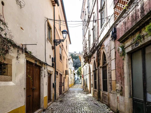 Portekiz, Avrupa 'daki eski Tomar kasabasında eski binaları olan dar bir sokak.