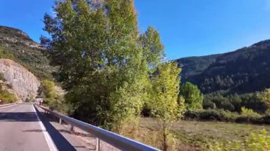 Driving through the landscape between Ainsa and Broto, showing dramatic cliffs, dense forests, and misty peaks of Ordesa Valley in the Pyrenees, Aragon, Spain.