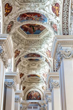 Passau, Almanya - 16 Nisan 2025: Passau, Almanya 'daki St. Stephans katedralinin içi, kulelerin ve ünlü organ borularının tepesinde yeşil metal kubbeleri bulunan eski bir beyaz kilise..