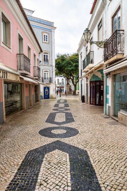 Portekiz 'deki Lagos' un tarihi bir parçası. Calcada Portuguesa adı verilen geometrik desenlerle döşenmiş sokak boyunca geleneksel renkli evler
