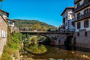 Elizondo, İspanya - 11 Ekim 2025: İspanya 'da Elizondo, Navarra sokaklarında yürümek. Klasik kırmızı ve beyaz cepheli geleneksel Bask evleri