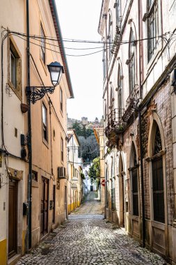 Portekiz, Avrupa 'daki eski Tomar kasabasında eski binaları olan dar bir sokak.